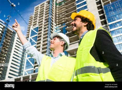 Architects On Large Construction Site Giving Instructions Stock Photo