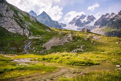 River Flowing In Green Landscape With Shelter And Iconic Mont Blanc