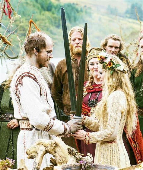 a group of people standing around each other with swords in their hands and flowers in their hair
