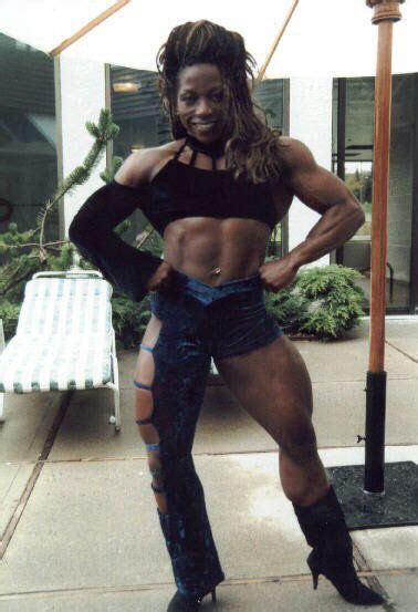 A Woman Posing For The Camera With Her Muscles Ripped Off And Boots On