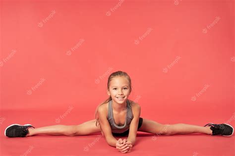 Premium Photo Cute Sporty Girl Doing Splits Against Red Background