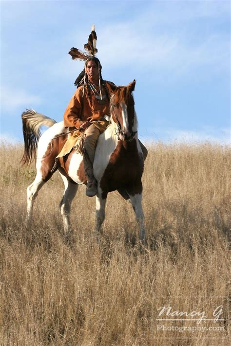 A Native American Man On Horseback Riding The Prairie Of South Dakota