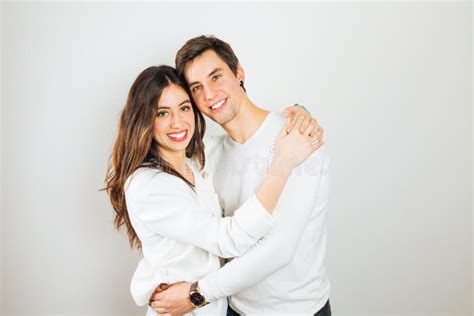 pares jovenes felices que abrazan en un fondo blanco imagen de archivo imagen de feliz