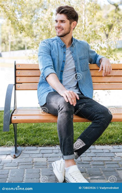 Handsome Young Man Sitting On A Bench Smiling Stock Photo Image Of