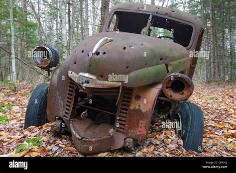 abandoned 1940s rusted international harvester pickup with bullet holes in forest near elbow