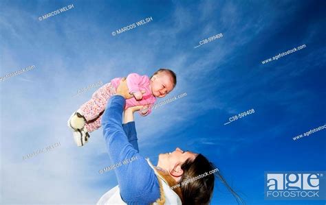 Mother Holding Her Baby Up In The Sky Stock Photo Picture And Rights