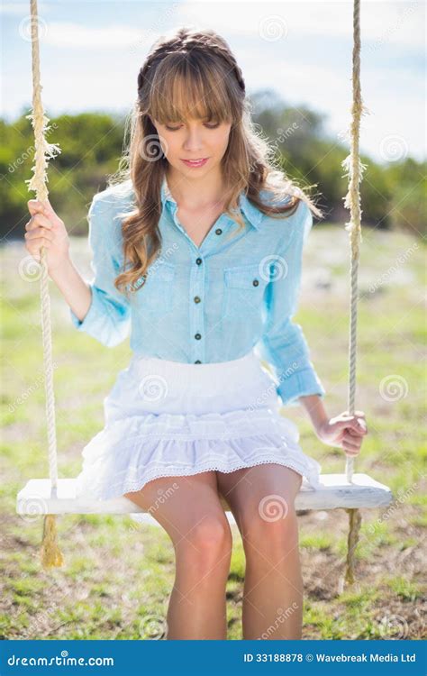 Pensive Young Model Posing While Sitting On Swing Stock Photo Image