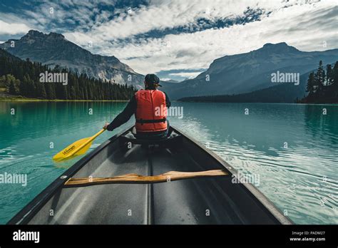 Young Man Canoeing On Emerald Lake In The Rocky Mountains Canada With