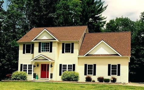 A house with a red roof stands out from the ordinary. yellow house red shutters - Google Search | Brown roofs, Brick house trim, Brown brick houses