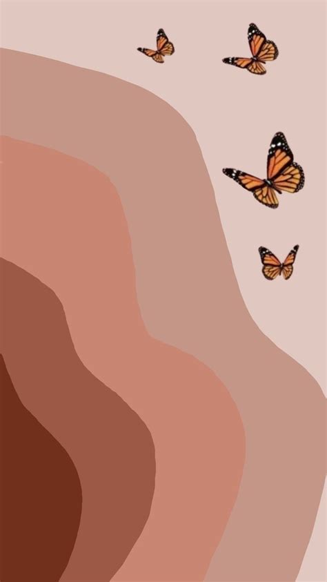 a group of butterflies flying in the air over a desert area with brown and pink colors