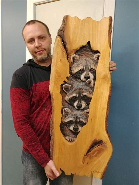 A Man Holding A Large Piece Of Wood With Raccoons On It