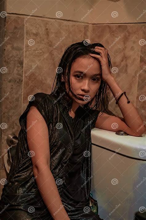 hot and wet asian girl poses with sensual style while wearing black wet dresses stock image