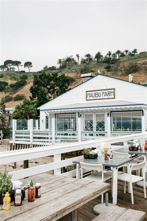 An Outdoor Dining Area With Wooden Tables And Benches On The Side Of A