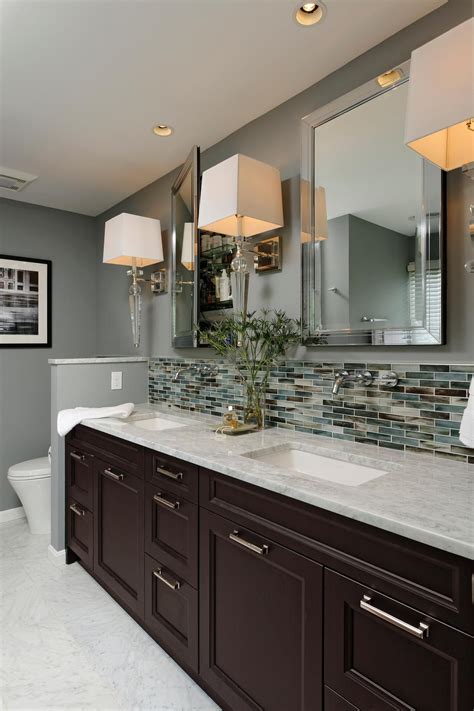 this gray contemporary bathroom features a double vanity design with a carrera marble countertop