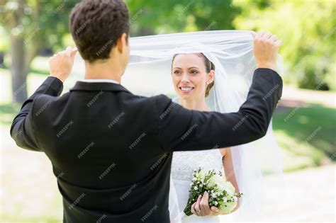premium photo loving groom lifting veil of bride