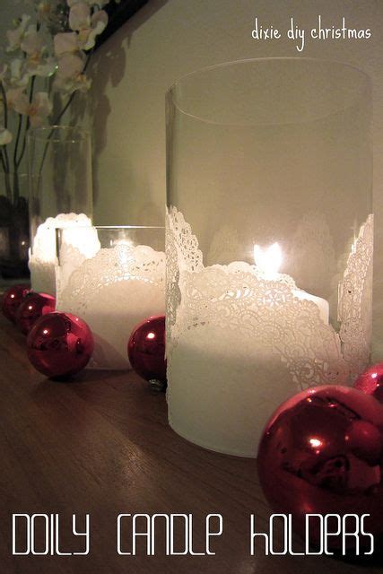Some Candles Are Sitting On A Table With Christmas Ornaments In Front