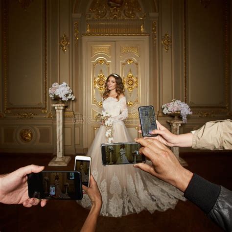 Guests Take Photographs Of The Bride On Smartphones Focus On