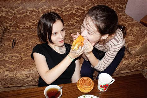 家里两个姐妹在沙发上喝着茶高清图片下载 正版图片504588709 摄图网
