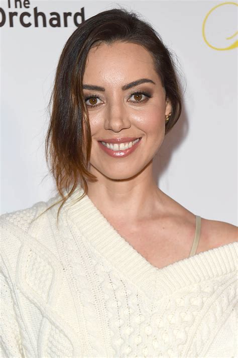 A Smiling Woman In A White Sweater Posing For The Camera With Her Hair