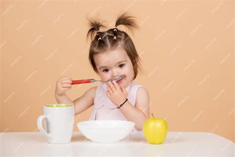 Premium Photo Cute Funny Babies Eating Baby Food Kid Girl Eating