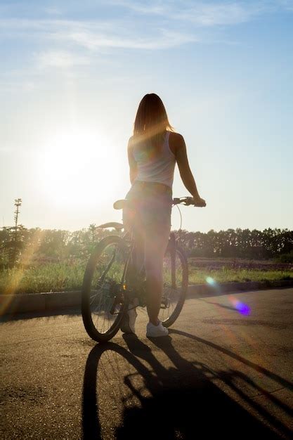 Premium Photo Girl Riding A Bike At Sunset
