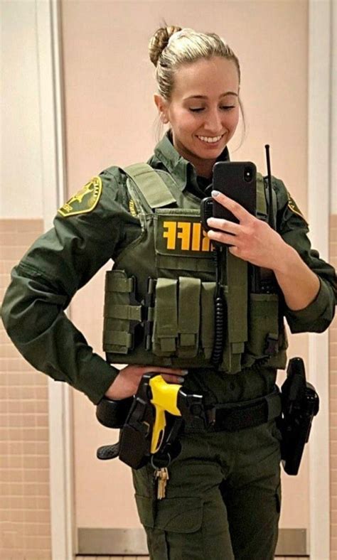 A Woman In Uniform Is Looking At Her Cell Phone