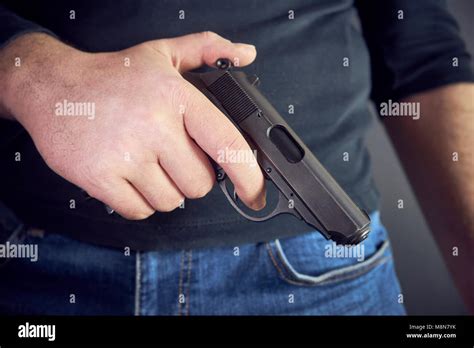 Killer Holding A Gun Side Him Cropped Shot Of Man Holding Gun In Hand