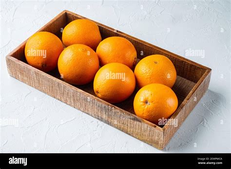 Raw Organic Cara Navel Oranges Set In Wooden Box On White Stone