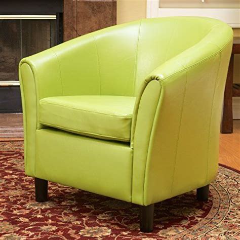 A Green Leather Chair Sitting On Top Of A Rug In Front Of A Fire Place