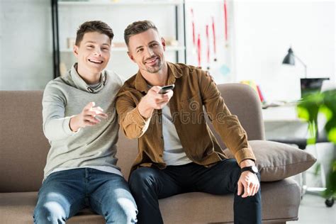 Padre Y Hijo Adolescente Sonrientes Viendo La Televisión Juntos Foto De