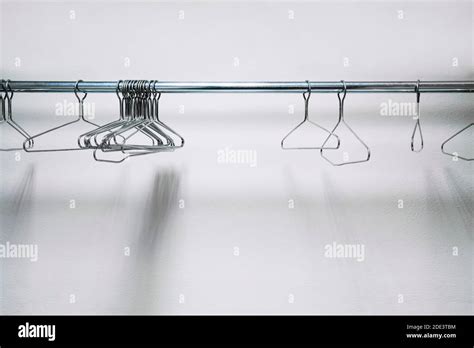 Metal Wire Clothes And Coat Hangers In Closet On White Background Stock