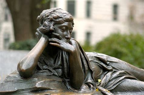A Statue Of A Woman With Her Hand On Her Face Sitting In Front Of A
