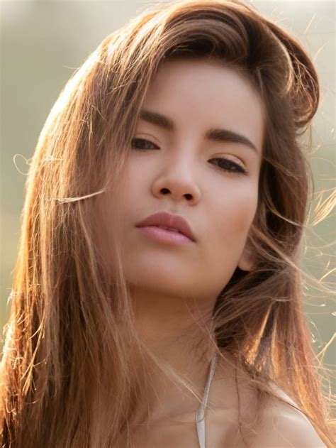 a woman with long brown hair is posing for the camera and has her eyes closed