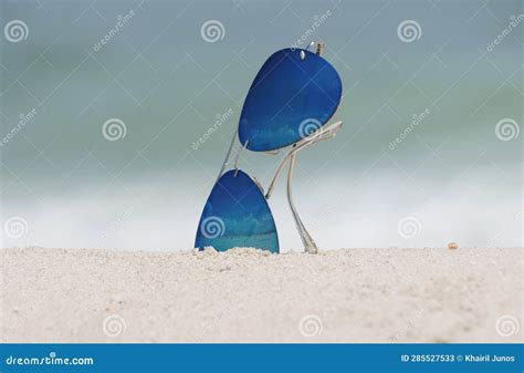 A Blue Sunglasses Partially Buried In The Sand At The Beach Stock Image