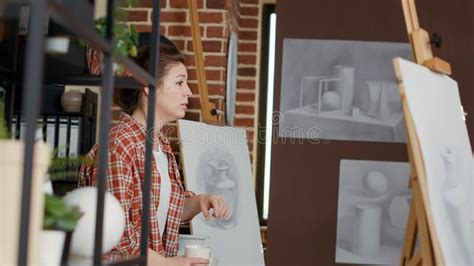 Female Artist Using Vase Model To Explain Drawing Technique Stock Photo