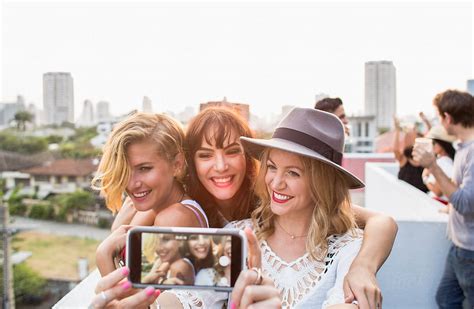 Three Girlfriends Taking A Selfie At A Party By Stocksy Contributor