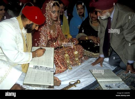 Newly Married Sikh Couple Signing The Civil Register After The Ceremony In The Gurdwara Stock