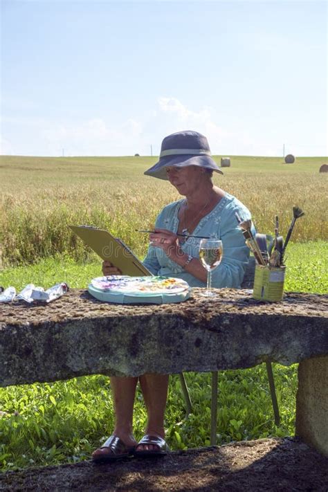 A Lady Artist Sits In Shade Working On A Painting Stock Photo Image