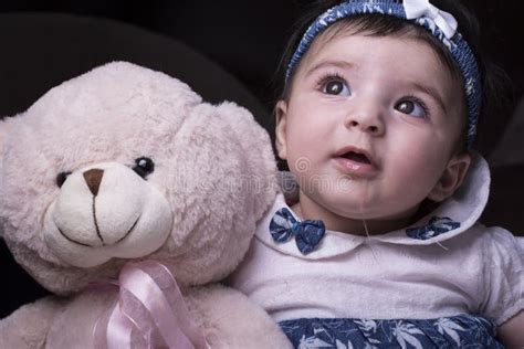 Close Up Of An Adorable Drooling Baby With Pink Teddy Stock Photo
