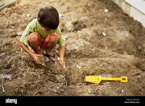 Six Year Old Boy Digging In The Garden Stock Photo Alamy