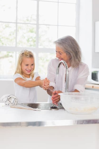 Premium Photo Smiling Grandmother And Granddaughter Washing Hands