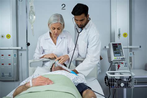 Doctor And Examining A Patient With Stethoscope And Placing A Oxygen Mask Stock Image Image Of