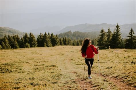Premium Photo Young Woman Walking With Backpack Over Green Hills