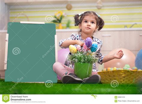 Cute Little Girl With Basket Full Of Colorful Easter Eggs Stock Photo