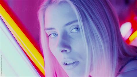 sensual woman licking her lips in neon lights by stocksy contributor clique images stocksy