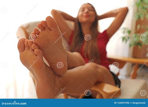Barefoot Young Woman Relaxing On Comfortable Chair Focus On Feet Stock