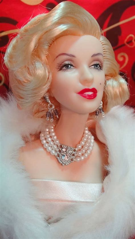 a close up of a doll wearing a white dress and fur collar with pearls on it