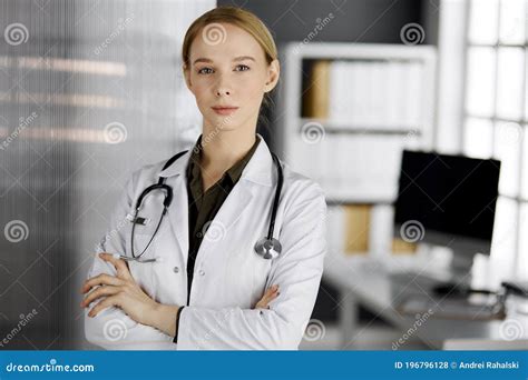 Friendly Smiling Female Doctor Standing In Clinic Portrait Of Friendly