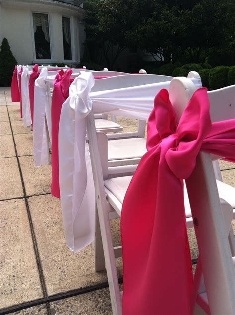 Wooden padded folding chairs, wedding ceremony setup. Hot Pink and White Satin chair sashes in a side box ...