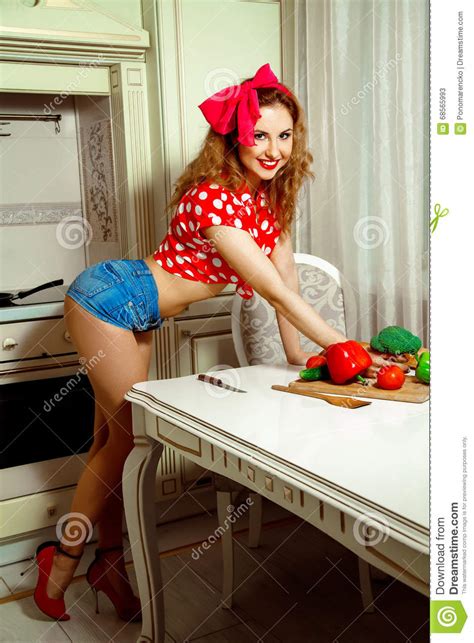 Pin Up Style Housewife Posing In The Kitchen And Smiling On Came Stock